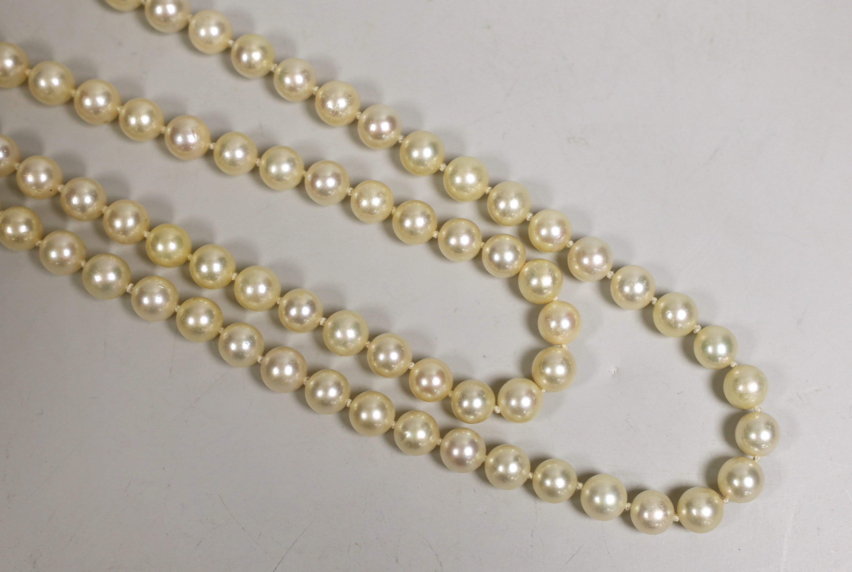 A twin strand cultured pearl necklace, with a cultured pearl and diamond chip set yellow metal clasp, 63cm.